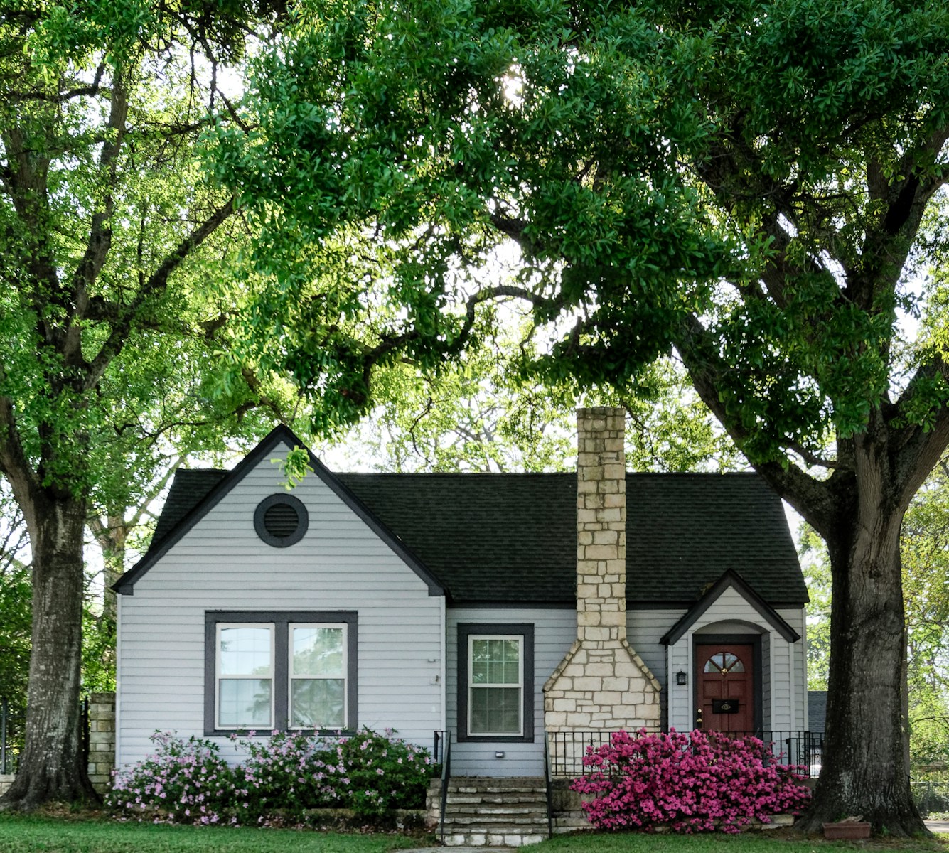 white and brown house surrounded by green trees